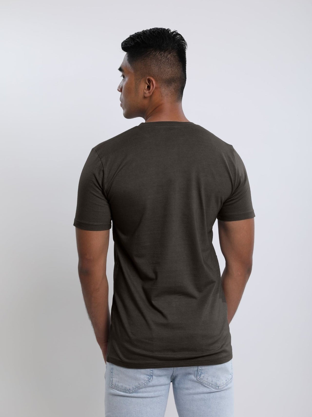 Photo from behind of a tall skinny guy wearing a dark grey tall t-shirt.