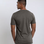 A shot from behind of a tall slim guy wearing a dark grey medium tall t-shirt.