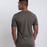 A shot from behind of a tall slim guy wearing a dark grey medium tall t-shirt.