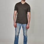 A head to toe shot of a tall and slim guy in the studio wearing a dark grey XL tall slim v-neck t-shirt.