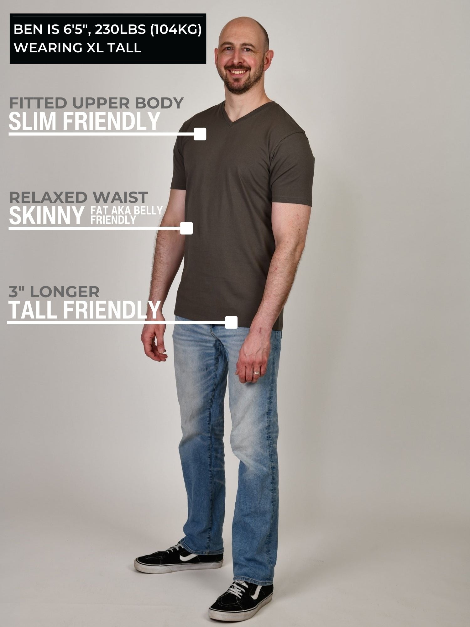 A head to toe shot of a tall and slim guy in the studio wearing a dark grey XL tall slim v-neck t-shirt.