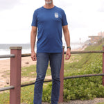 A head to toe shot of a tall slim guy in an L tall graphic t-shirt with a lake design.