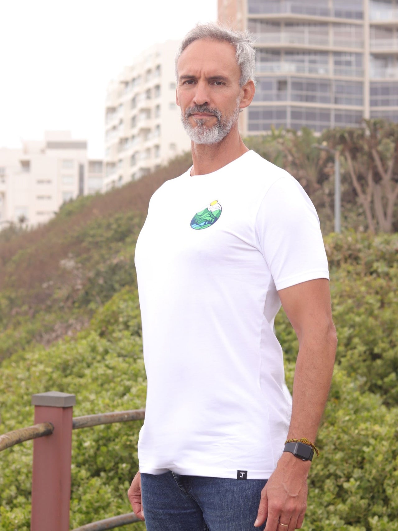 An upper body shot of a tall slim guy in an L tall graphic t-shirt with a landscape design.