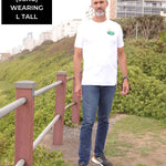 A head to toe shot of a tall slim guy in an L tall graphic t-shirt with a landscape design.