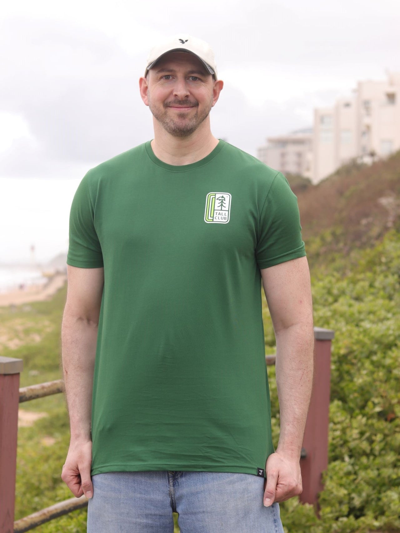 A tall slim guy in an XL tall graphic t-shirt with a tall club design.