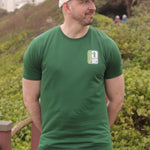 An upper body shot of a tall slim guy in an XL tall graphic t-shirt with a tall club design, hands behind back.