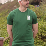 An upper body shot of a tall slim guy in an XL tall graphic t-shirt with a tall club design, hands behind back.