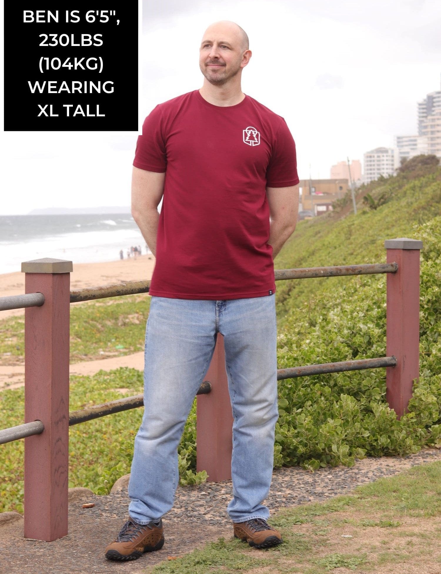 A head to toe shot of a tall skinny guy wearing an XL tall graphic t-shirt with a tree design.