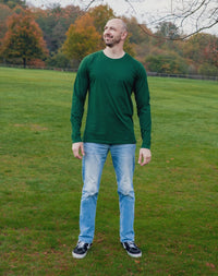 Thumbnail for A head to toe shot of a tall athletic guy in a park, looking up at the sky and wearing a dark green long sleeve tall t-shirt.