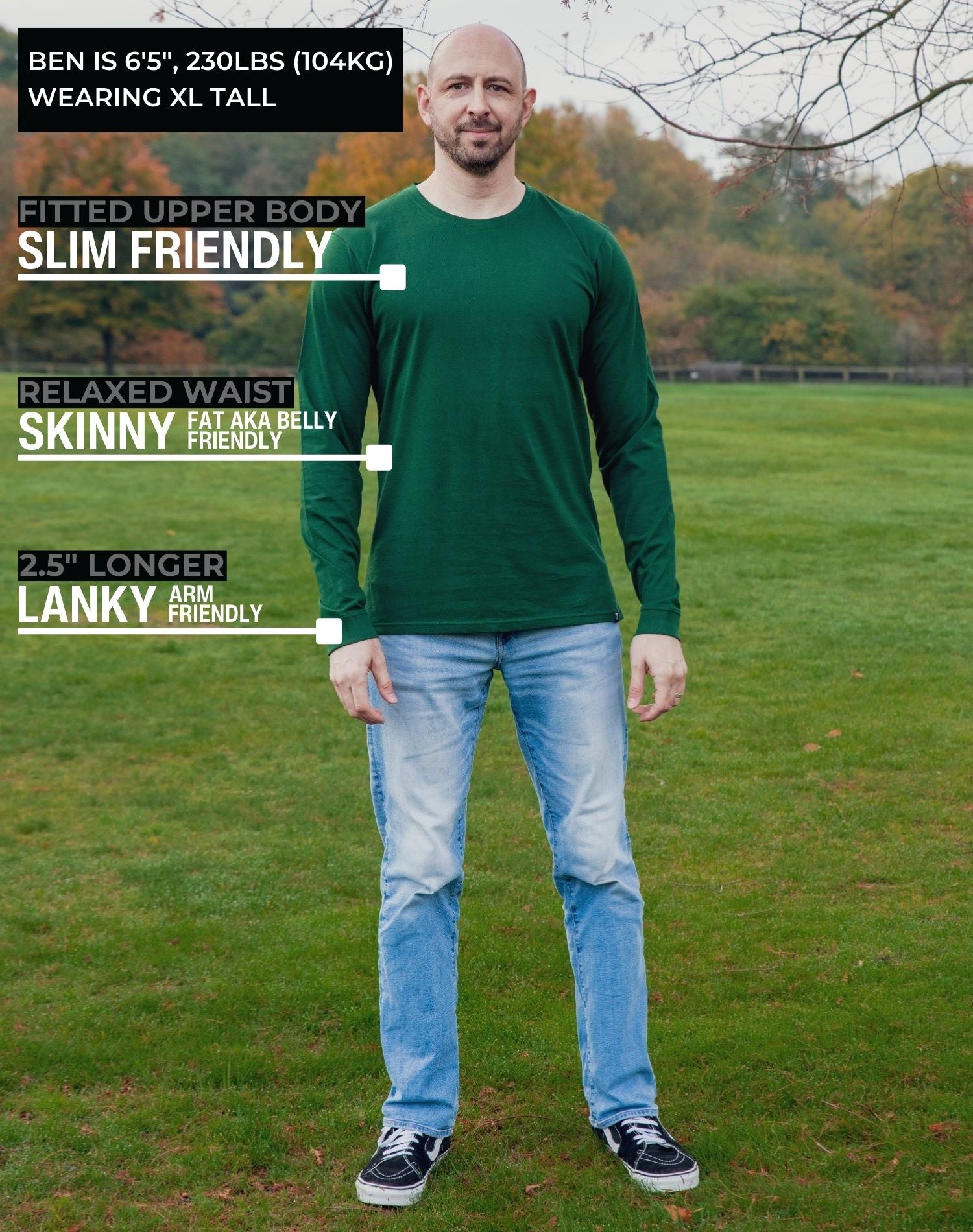 A head to toe shot of a tall athletic guy in a park wearing a dark green long sleeve tall t-shirt.