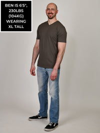 Thumbnail for A head to toe shot of a tall and slim guy in the studio wearing a dark grey XL tall slim v-neck t-shirt.