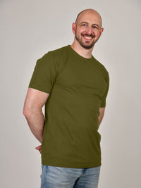 Thumbnail for A shot of a tall athletic guy, hands behind back, wearing a military green XL tall t-shirt.