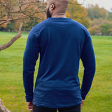 A shot from behind of a tall athletic guy wearing a long sleeve navy tall t-shirt.