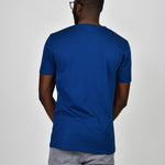 A shot from behind of a tall and slim guy in the studio and wearing a navy L tall slim t-shirt.