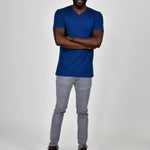 A head to toe shot of a tall and slim guy in the studio wearing a navy blue L tall slim v-neck t-shirt.