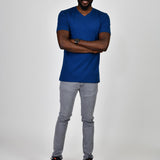 A head to toe shot of a tall and slim guy in the studio wearing a navy blue L tall slim v-neck t-shirt.