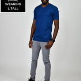 A head to toe shot of a tall and slim guy in the studio wearing a navy blue L tall slim v-neck t-shirt.