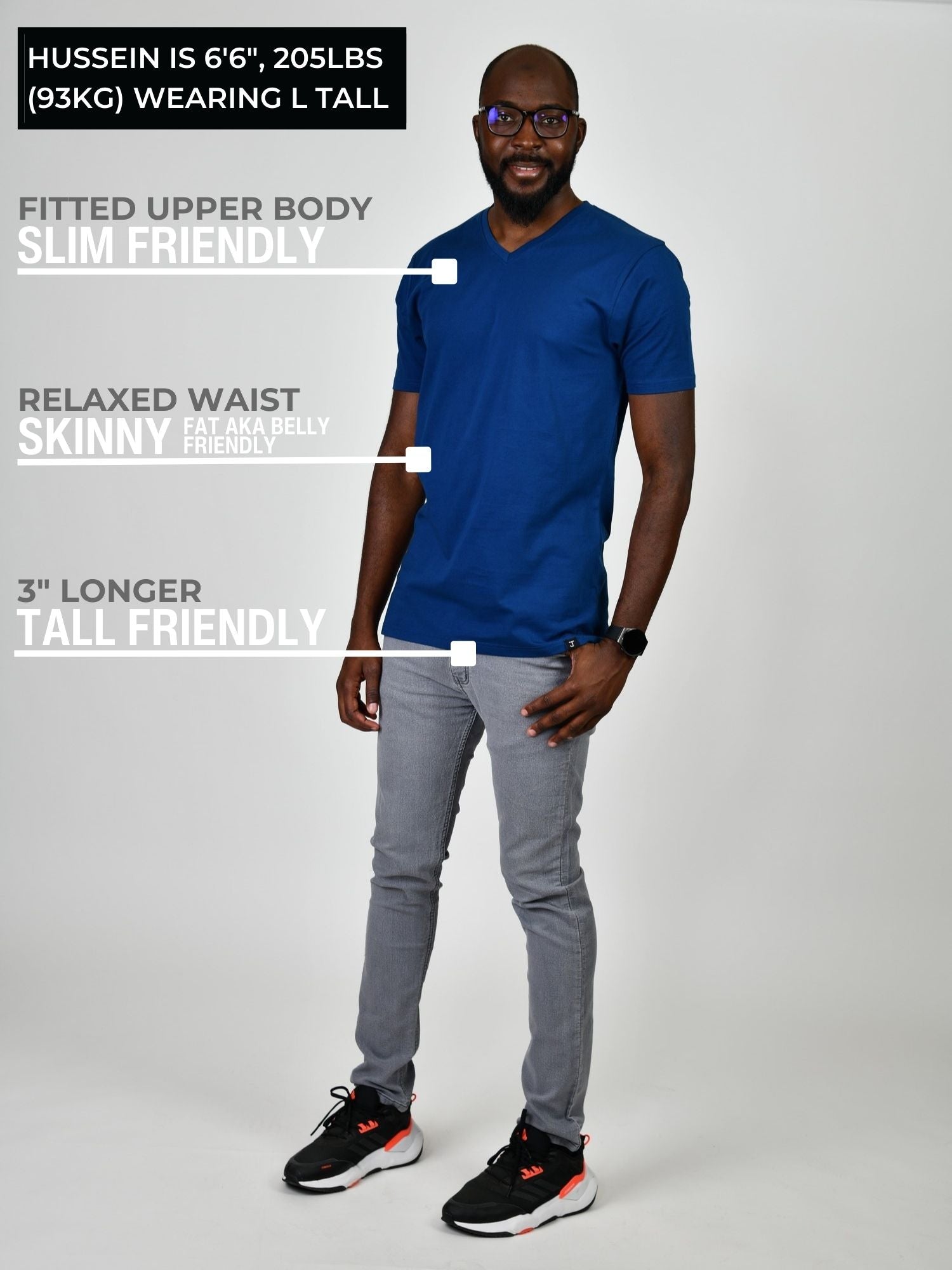 A head to toe shot of a tall and slim guy in the studio wearing a navy blue L tall slim v-neck t-shirt.