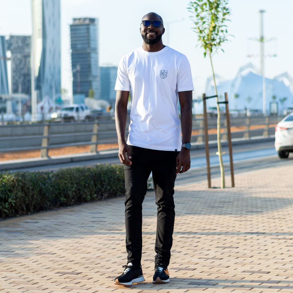A tall guy wearing a white tall graphic t-shirt.