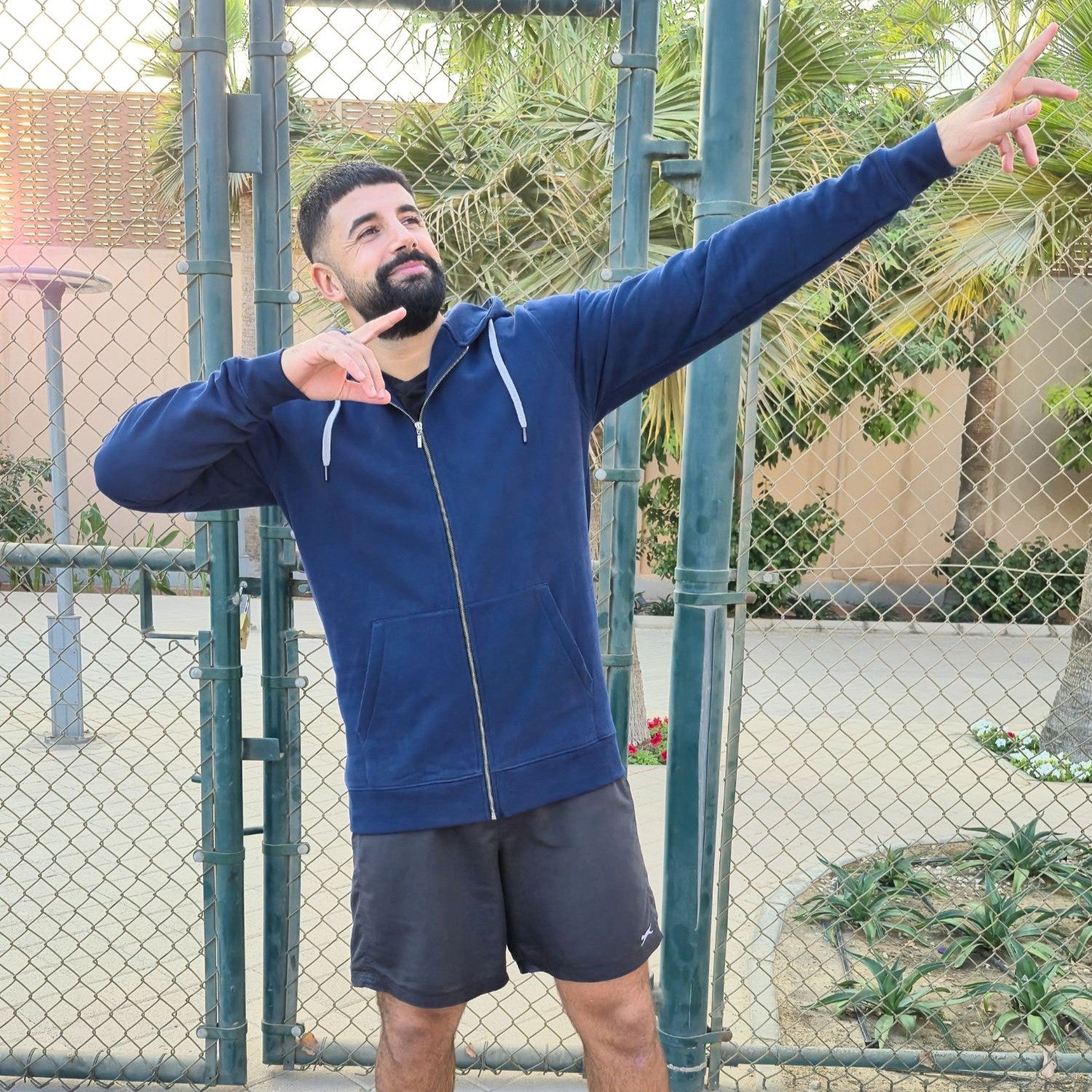 A tall and broad guy striking a funny pose in a dark navy XL tall hoodie