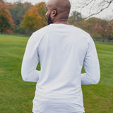 A shot from behind of a tall athletic guy wearing a long sleeve white tall t-shirt.