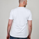 A shot from behind of a tall and slim guy in the studio and wearing a white XL tall slim t-shirt.
