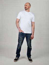 Thumbnail for A head to toe shot of a tall and slim guy, hand in pocket, in the studio wearing a white XL tall slim t-shirt.