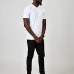 A head to toe shot of a tall and slim guy in the studio wearing a white L tall slim v-neck t-shirt.